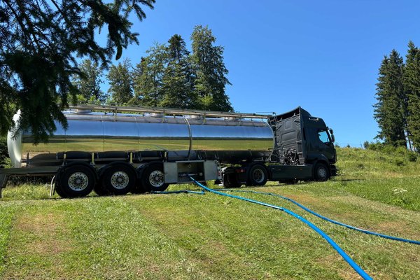 Ansicht Tankwagen pumpt Trinkwasser in die Behälter